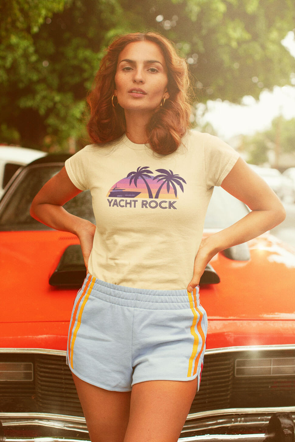 Woman leaning on classic car wearing A Yacht Rock Sunset tee shirt in the 1970's.